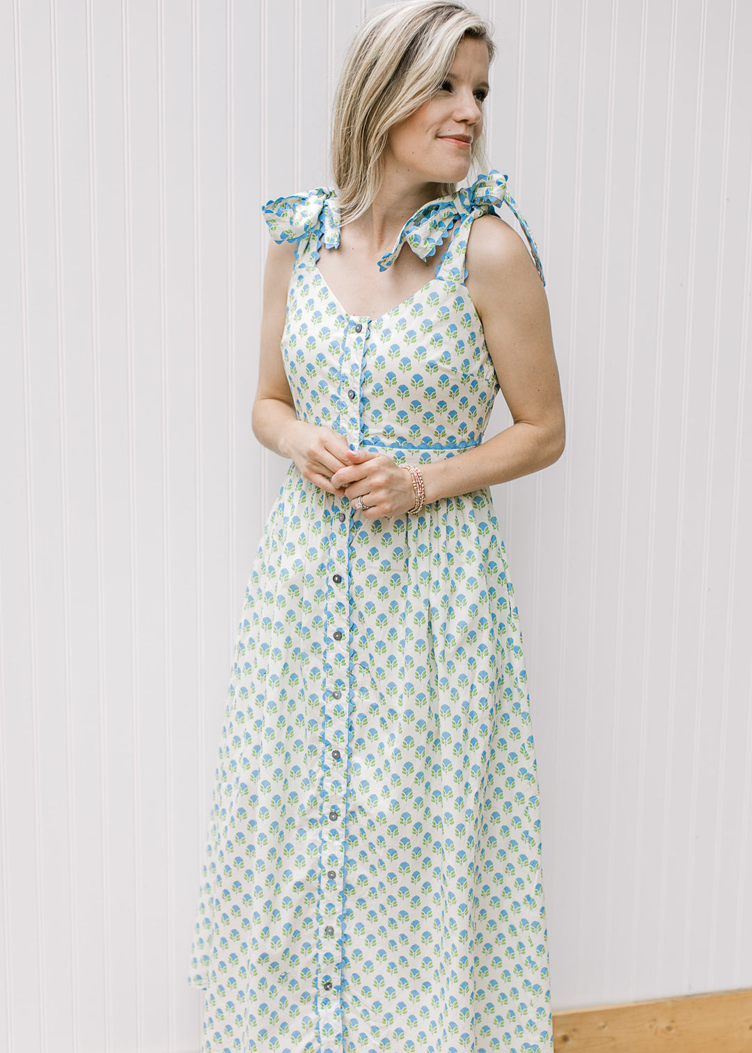White dress with shoulder ties printed with blue and green pattern and ric rac trim.