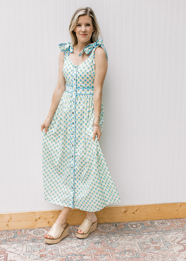 Full view of Blonde model in white dress with blue and white print and shoulder tie.
