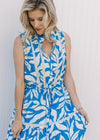 Close up of tie waist and lace inset detail along the bodice and skirt of a blue and white maxi.