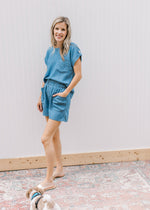 Model wearing sandals with a chambray set with elastic waist in shorts and patch pocket on top.