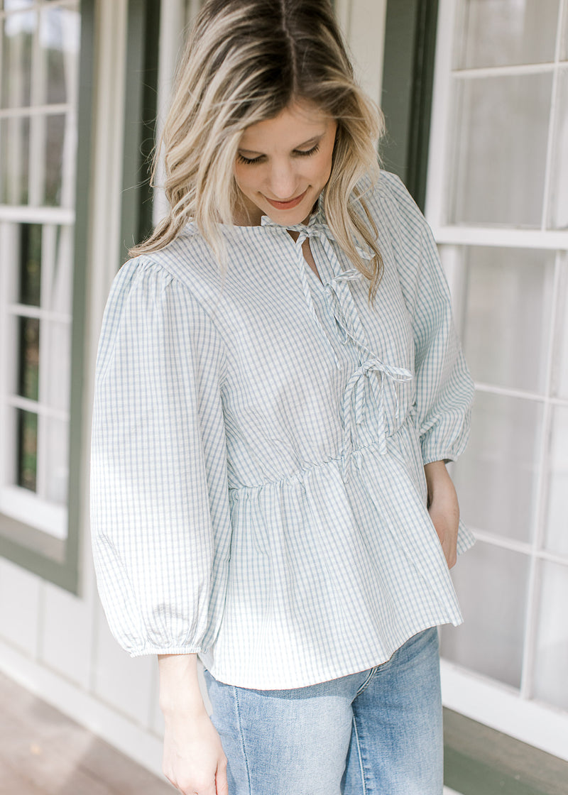 Model wearing a blue and white windowpane checks, 3/4 bubble sleeves and 3 bow front.