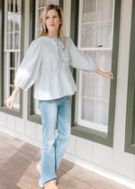 Model wearing jeans and a blue and white windowpane checks, 3/4 bubble sleeves and 3 bow front.