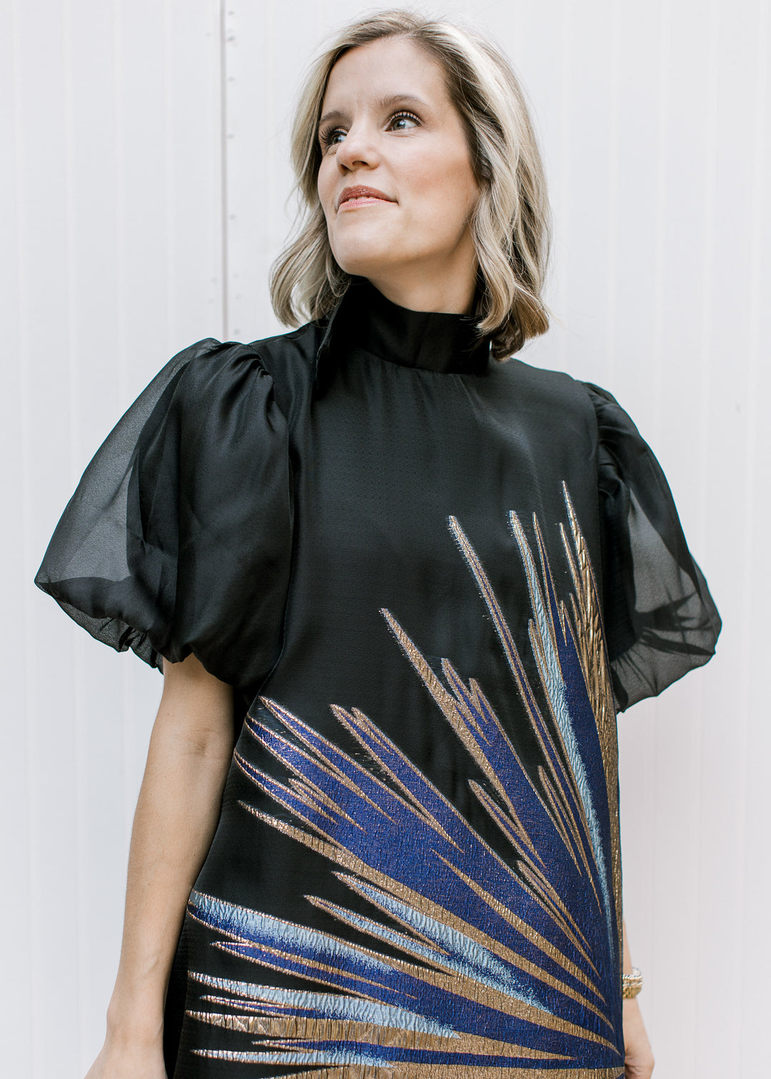 Front close-up of Blue Flame Dress showing black mock neckline, sheer bubble sleeves and metallic starburst detail.