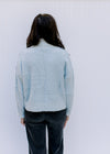 Back view of Model wearing a blue and gray colorblock turtleneck sweater with long sleeves. 