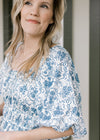 Close up of smocked neck, boatneck and bubble short sleeves on a cream midi with blue floral. 