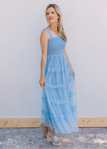 Model wearing wedges with a pale blue maxi with a smocked bodice and tiered mesh skirt.