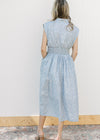 Back view of Model wearing a sleeveless blue and white checked midi with a front zipper. 
