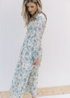 Side view of Model wearing a cream midi with blue roses, an elastic waist and sheer 3/4 sleeves.