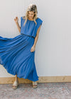 Model wearing a blue skirt set, with a cropped balloon top and pleated skirt with elastic waist. 
