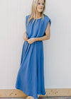 Model wearing a blue skirt set, top has a cropped balloon silhouette and the midi skirt is pleated.