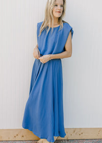 Model wearing a blue skirt set, top has a cropped balloon silhouette and the midi skirt is pleated.