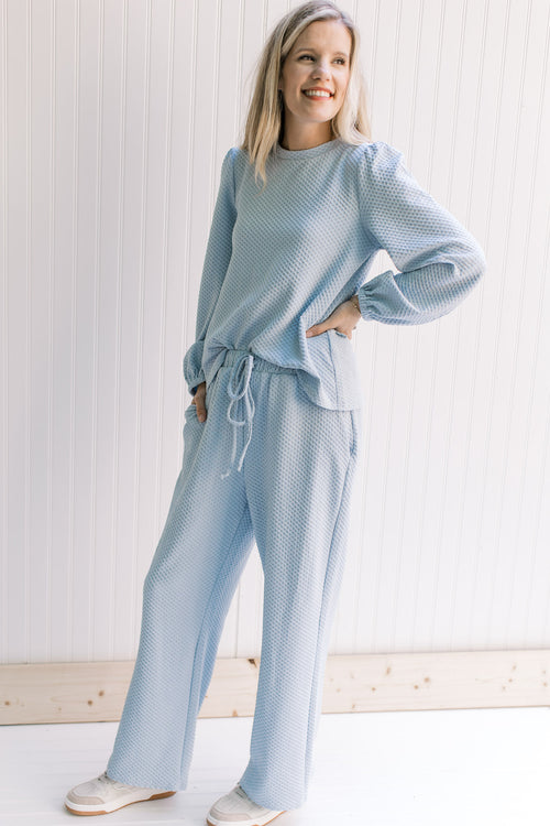 Model wearing a waffle grid baby blue top with bubble long sleeves, a round neck and matching pants.