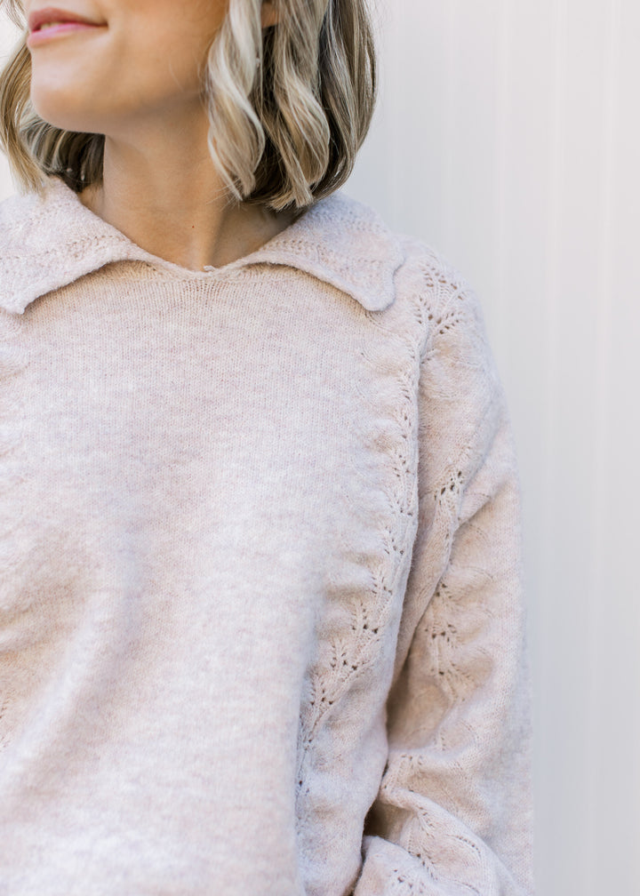 Model wearing a soft blush sweater with scalloped flap collar, long sleeves and knit detail. 