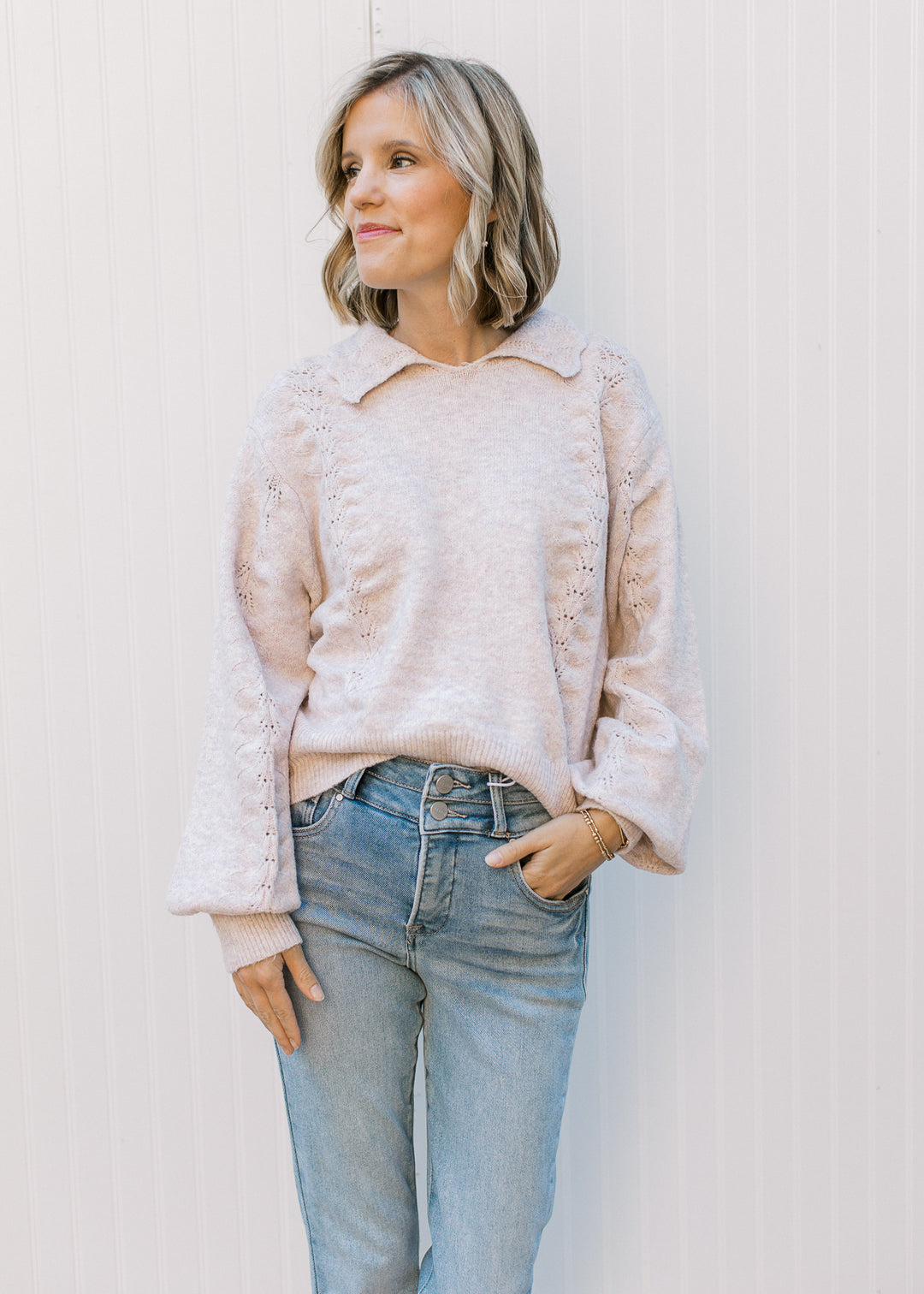 Model wearing jeans and a soft blush sweater with scalloped flap collar, long sleeves.