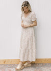 Model wearing a cream tiered maxi with pink microfloral, v-neck and bubble short sleeves.