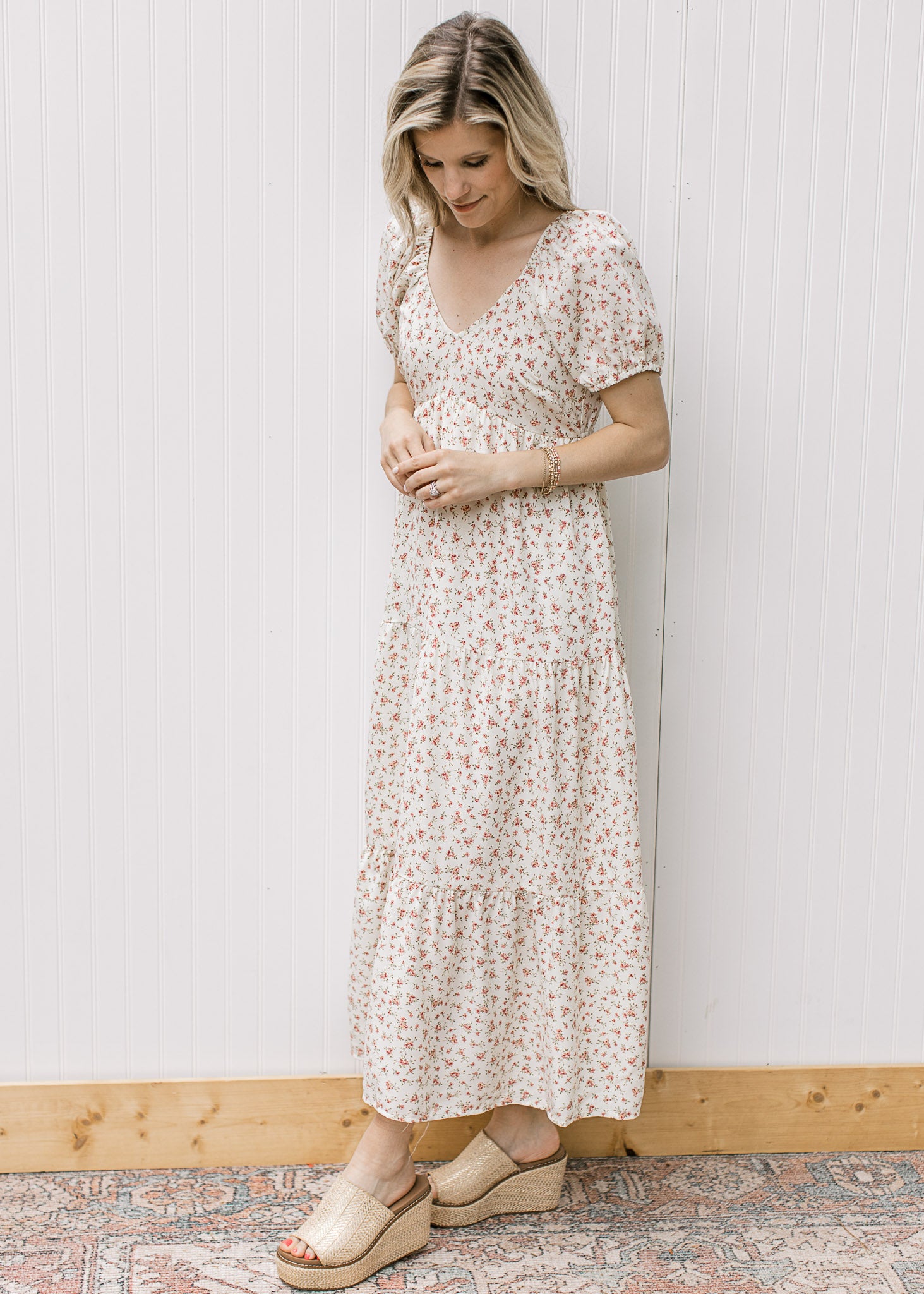 Model wearing a cream tiered maxi with pink microfloral, v-neck and bubble short sleeves.