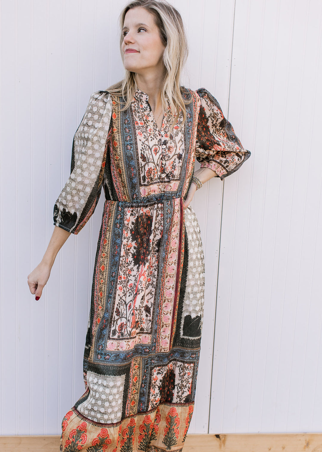 Model wearing a bohemian patterned midi with a button v-neck, 3/4 sleeves and elastic waist.