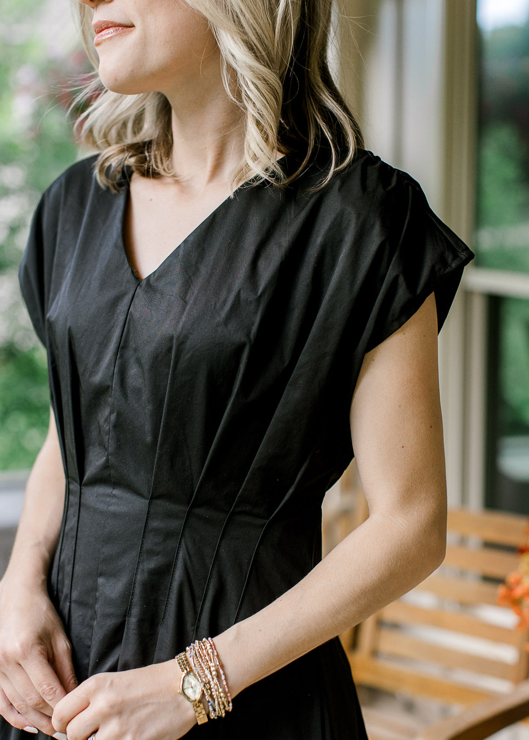 Close up of v-neckline and capped sleeves on a black and cream color block midi. 