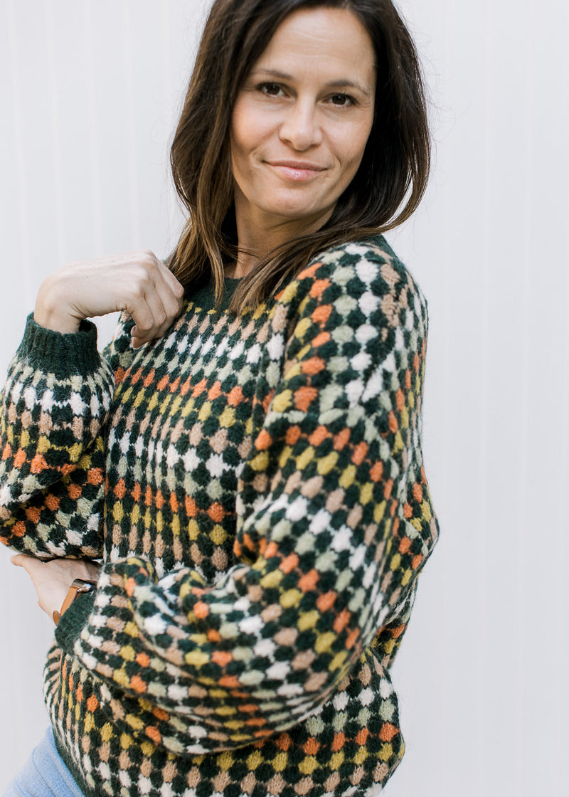 Close up of bubble long sleeve and extended shoulder on a navy sweater with fall dots.