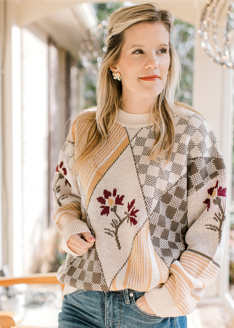 Model wearing a long sleeve sweater with geometrical botanical print and a round neck. 