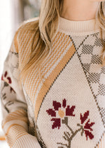 Close up of geometrical botanical print on a long sleeve sweater with a round neck.  