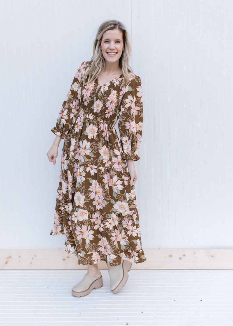 Model wearing mules with a brown maxi with a pink, cream and green floral pattern and 3/4 sleeves.