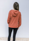 Back view of brick colored long sleeve sweatshirt with an extended shoulder and a hood. 