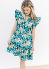 Model wearing a tiered bright blue floral dress with ruffle cap sleeves and a v-neck.