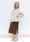 Model wearing cream sweater over a brown midi with knit material, short sleeves and a v-neck. 