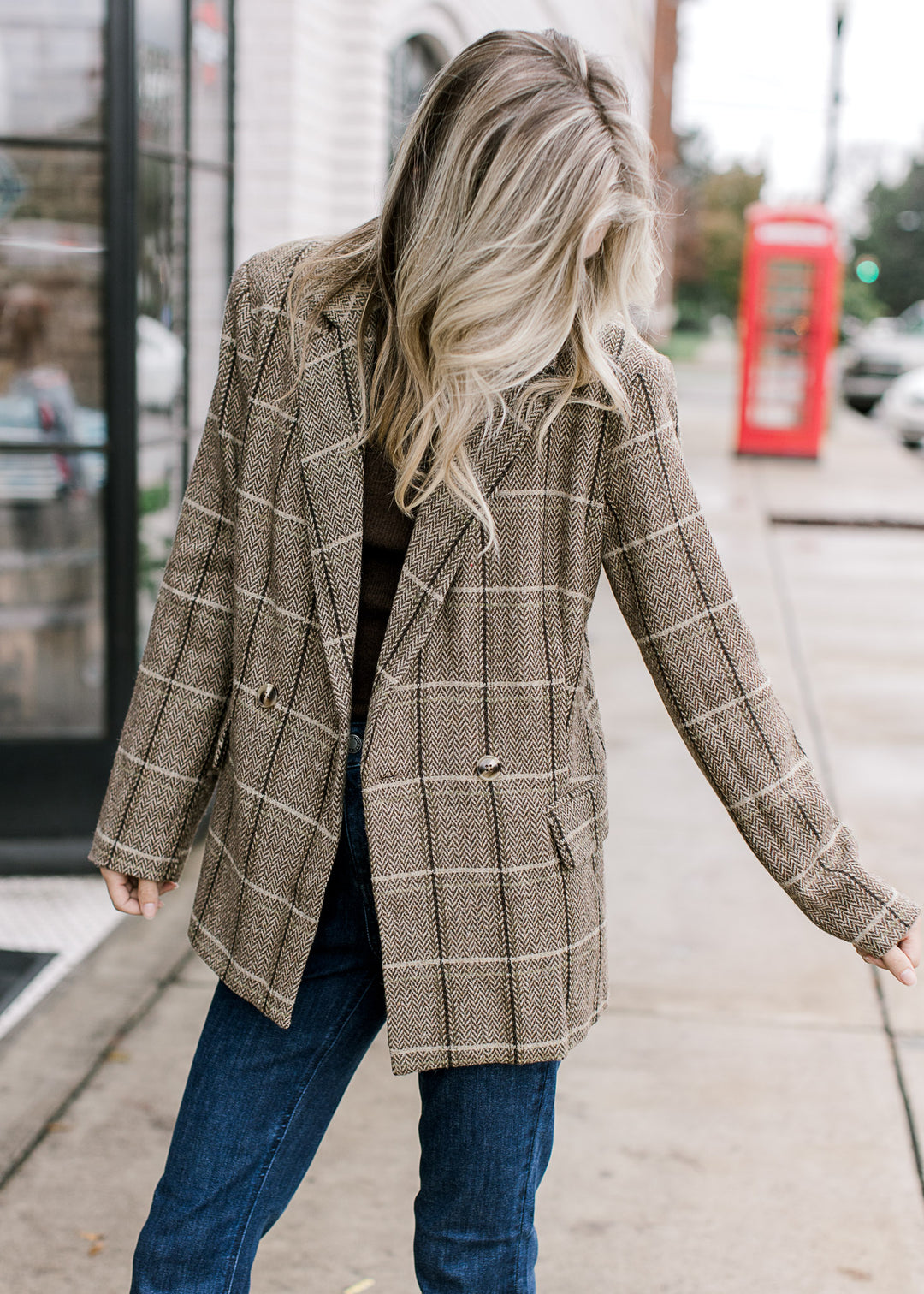 Model wearing a soft wool brown and cream plaid blazer with double-breasted front and faux pockets. 