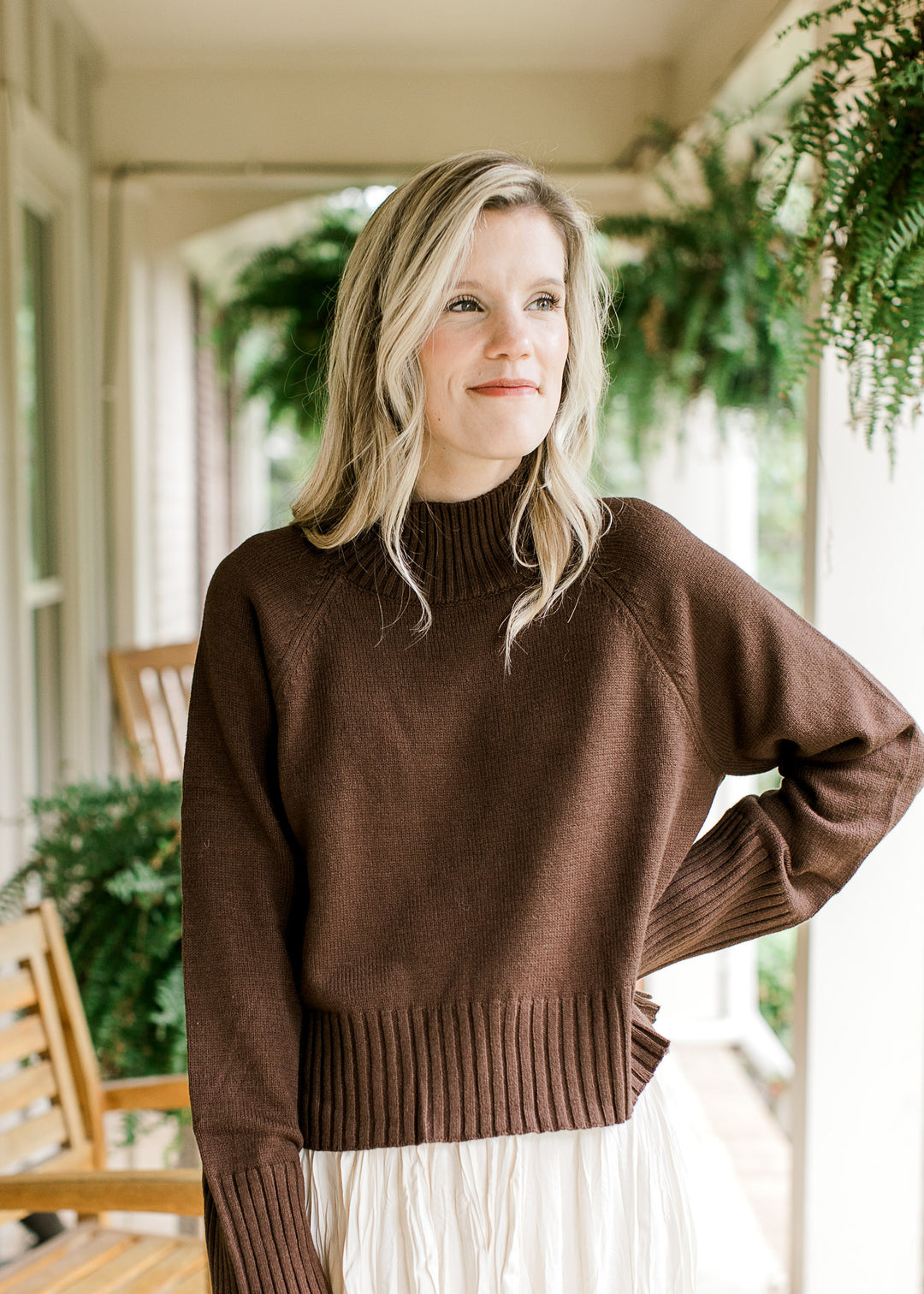 Model wearing a brown sweater with a mock neckline and long sleeves with ribbed neck, cuff and hem.