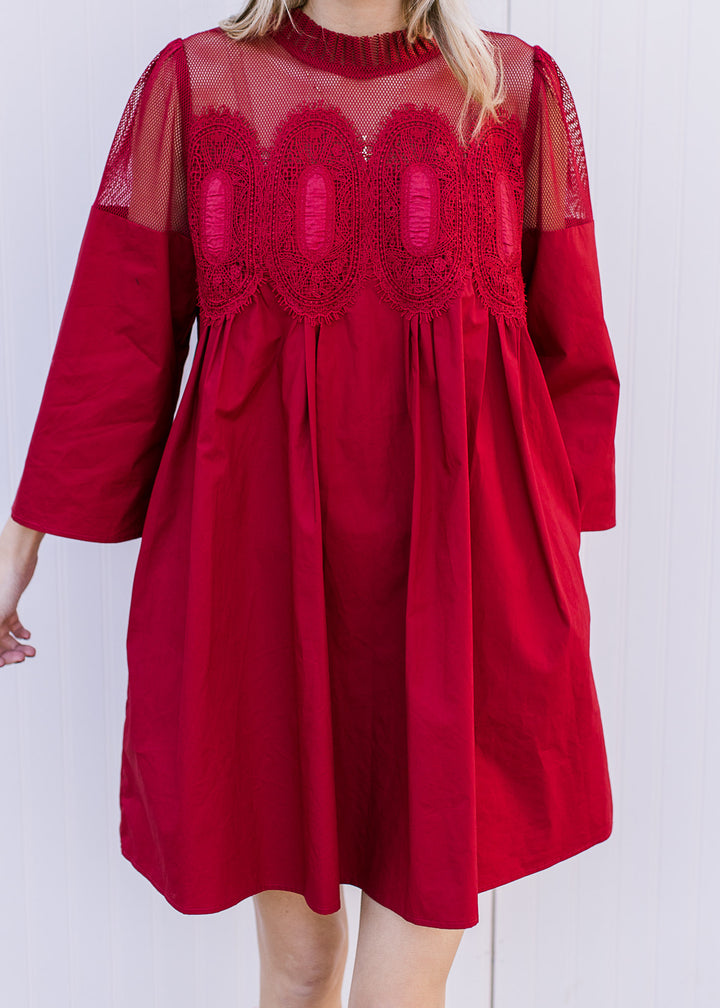 Model wearing a Burgundy dress with 3/4 sleeves and mesh lace neckline with embroidered medallions.