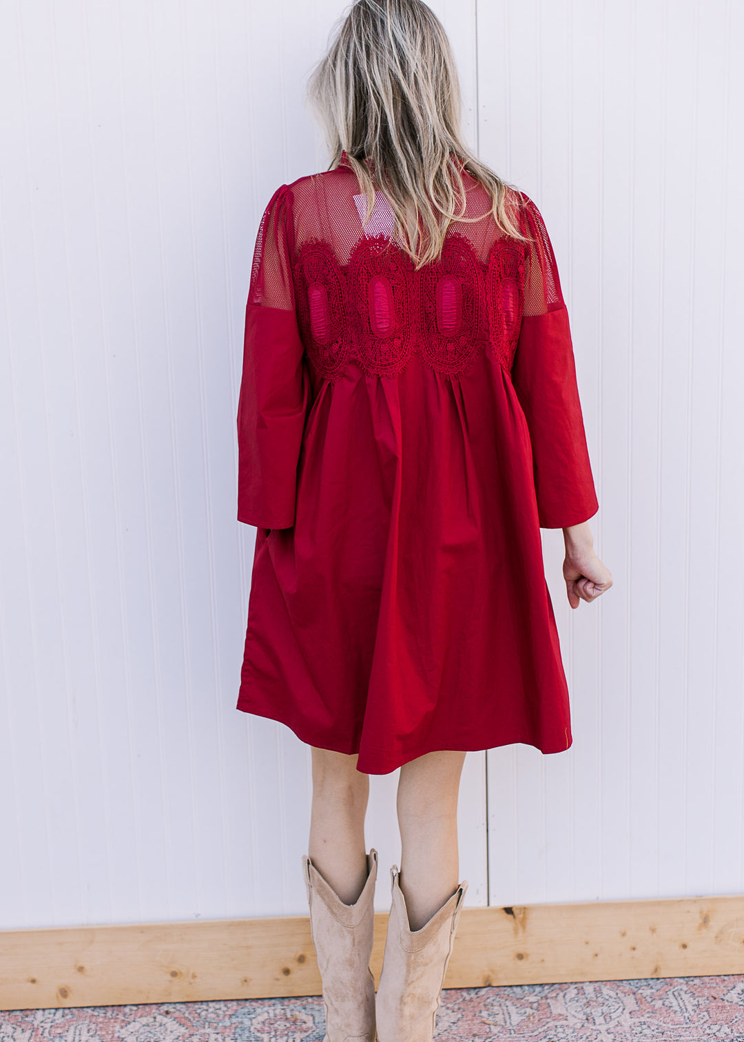 Back view of Model wearing a Burgundy Red dress with 3/4 sleeves and mesh lace neck with medallions.