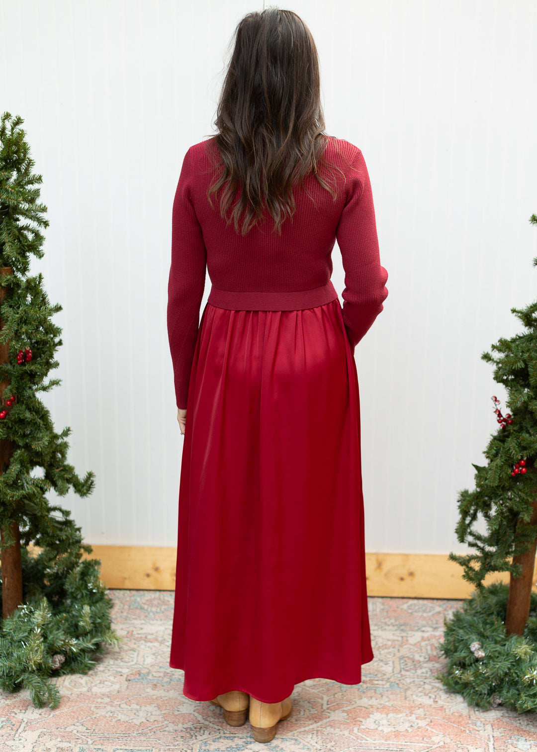 Back view of burgundy sweater dress with long sleeves, ribbed knit bodice and gathered satin maxi skirt.