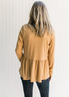 Back view of Model wearing a ribbed butterscotch top with long sleeves, a v-neck and a babydoll fit.