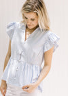 Model wearing a lightweight blue and white striped button up, v-neck top with ruffle short sleeves.