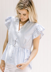 Model wearing a lightweight blue and white striped button up, v-neck top with ruffle short sleeves.