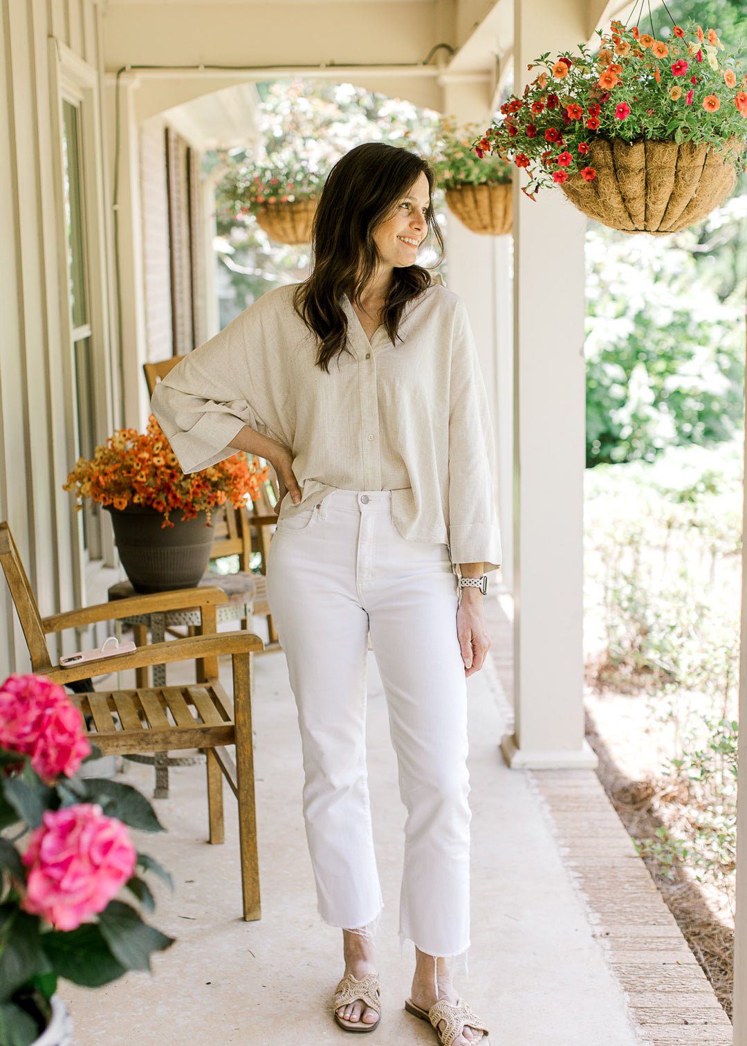 Model wearing an oatmeal top with button front, v-neckline, cuffed 3/4 sleeves and a high-low hem.