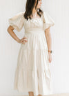 Model wearing a champagne  midi with bubble short sleeves, square neck and a smocked back.