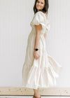 Side view of Model wearing a champagne tiered midi with bubble short sleeves and a square neck.