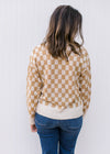 Back view of Model wearing a cream and camel checked sweater with long sleeves and round neck.