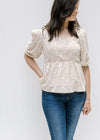 Model wearing a fully lined white top with a camel floral pattern, square neckline and 3/4 sleeves. 