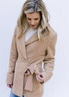 Model wearing a camel coat with long sleeves, a collard neck and a side tie closure. 