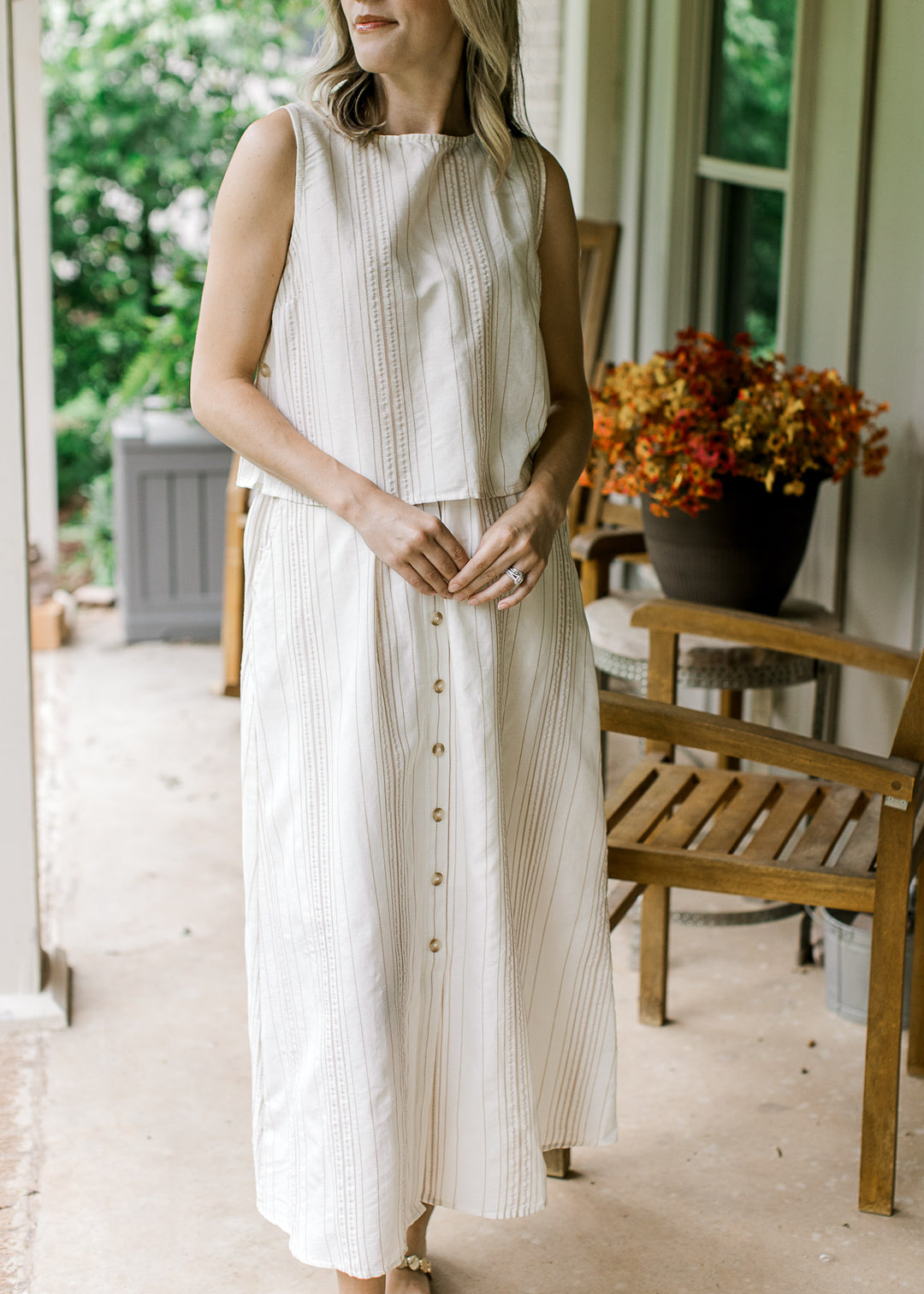 Model wearing a cream top with camel stripes and boatneck with matching midi skirt.