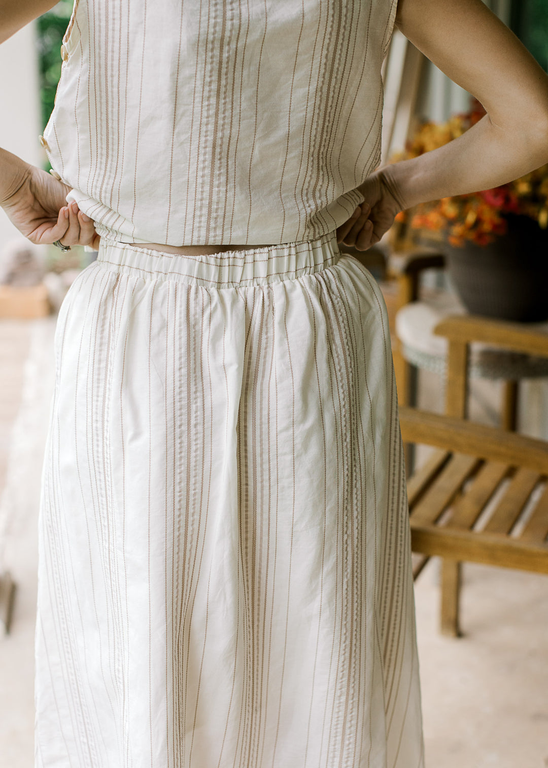 Close up of back of cream midi skirt with camel stripes, elastic waistband and matching top. 
