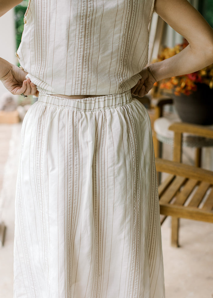 Close up of back of cream midi skirt with camel stripes, elastic waistband and matching top. 