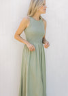 Model wearing a sleeveless celery green midi with a ribbed knit top and a lined flowy skirt.