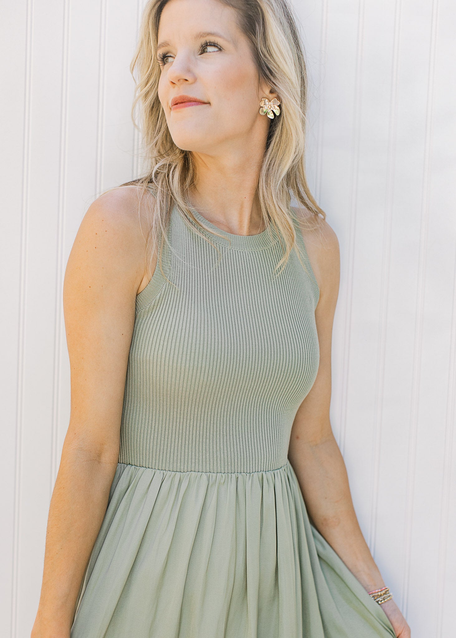 Close up of sleeveless knit ribbed top on a celery green midi with a lined flowy skirt. 