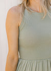 Close up of sleeveless, ribbed knit top on soft green midi with a flowy lined skirt. 