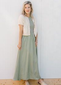 Model wearing cream short sleeve cardigan and a sleeveless celery green midi. 